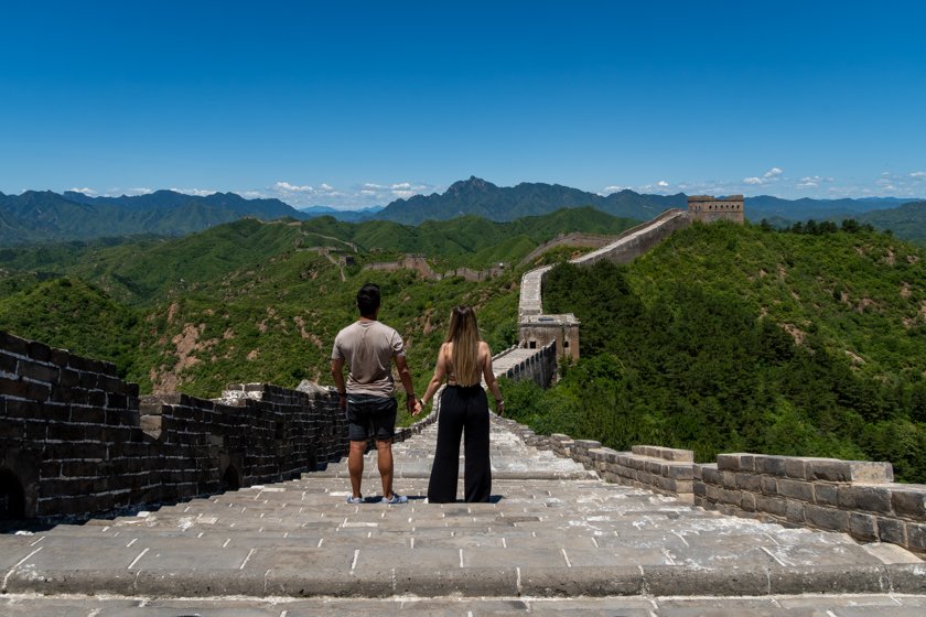 Pareja de espaldas contemplando la Gran Muralla China durante los preparativos de su viaje
