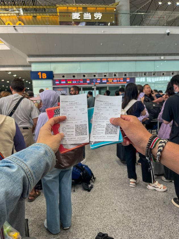 Pasaporte y billetes de tren en una estación de China